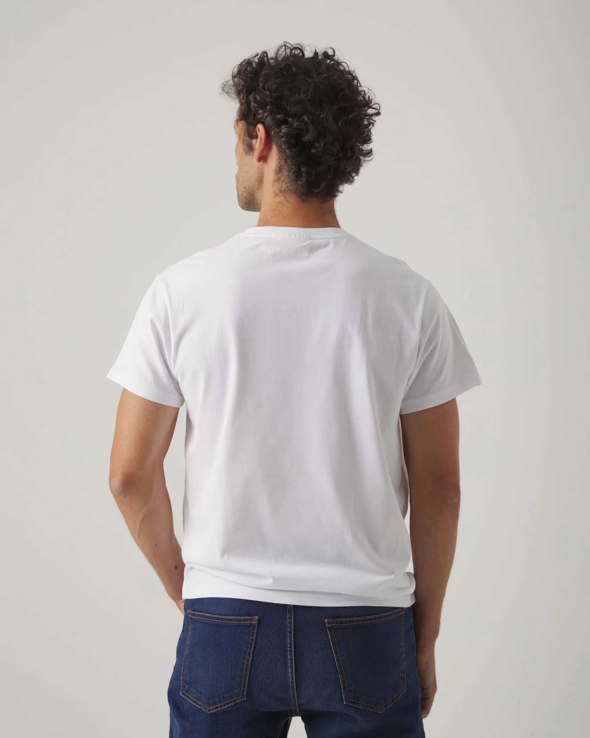 Camiseta blanca con cuello redondo y manga corta, con letras y moto Scotta en el torso.