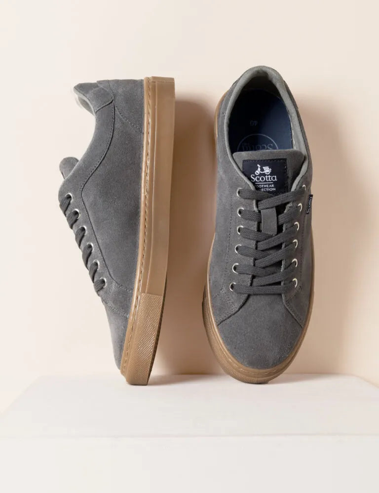 Zapatilla baja con cordones gris.