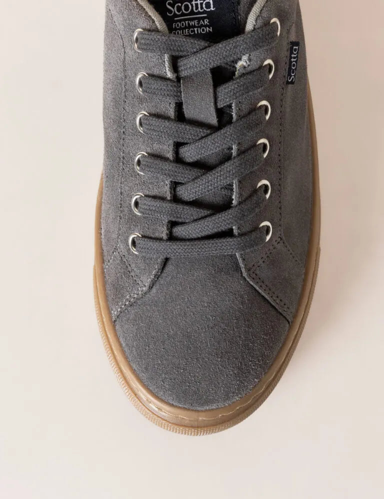 Zapatilla baja con cordones gris.