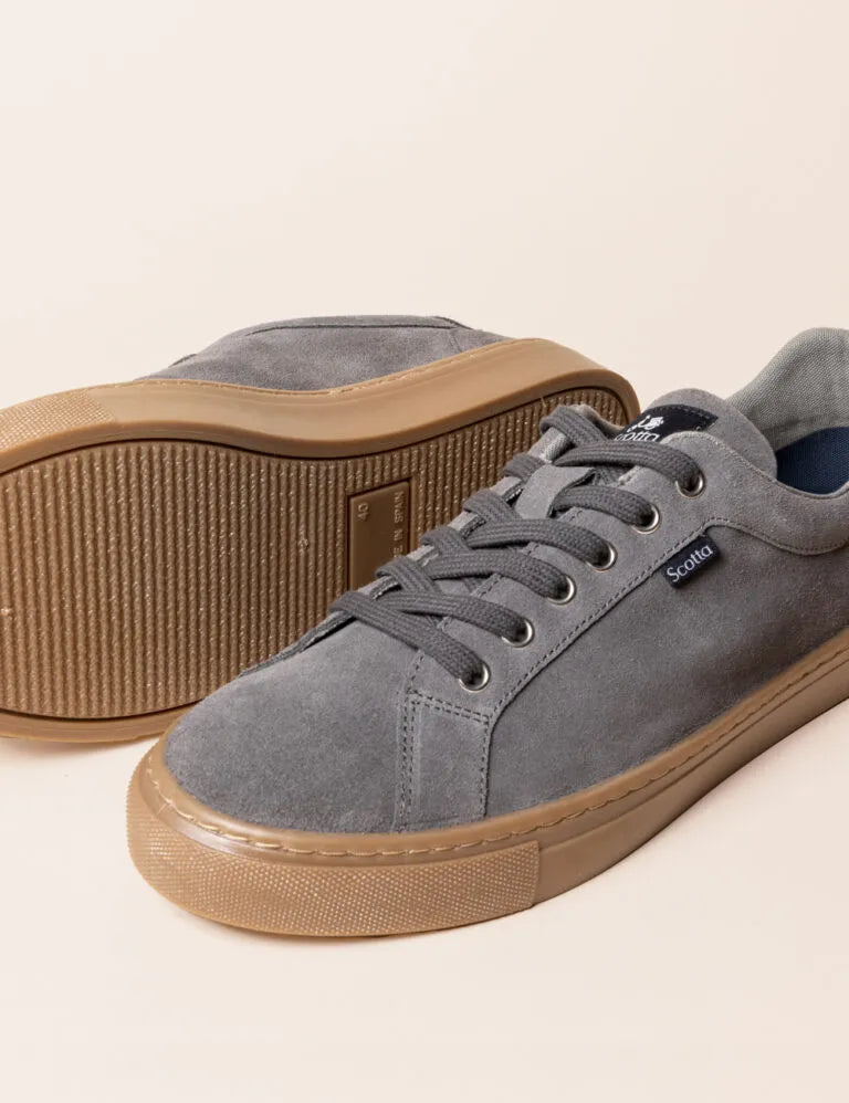 Zapatilla baja con cordones gris.